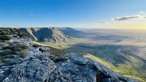 Rock ledges at the plateau edge with the distant plain below