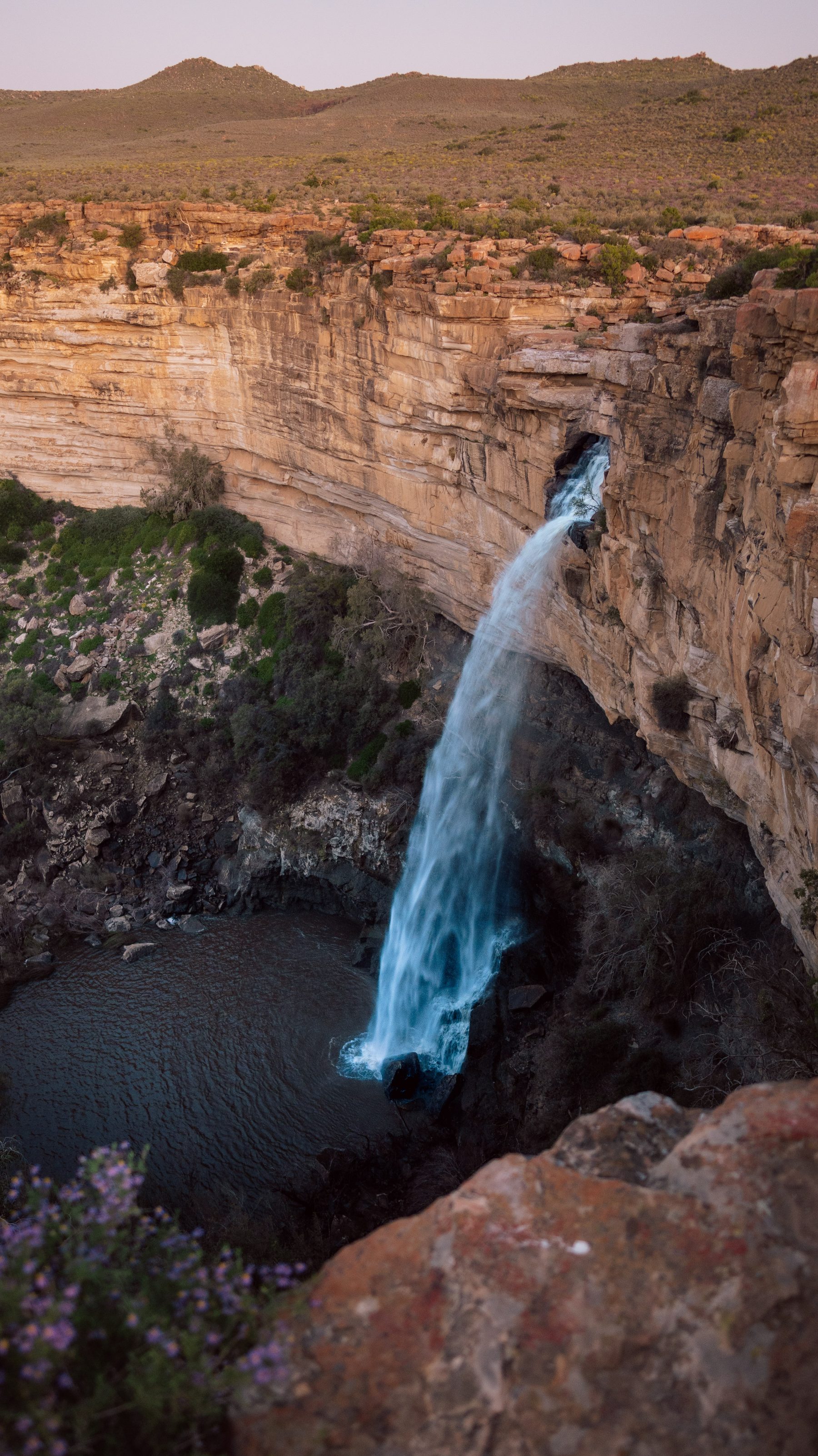 A waterfall on the plateau edge with spring vegetation around it