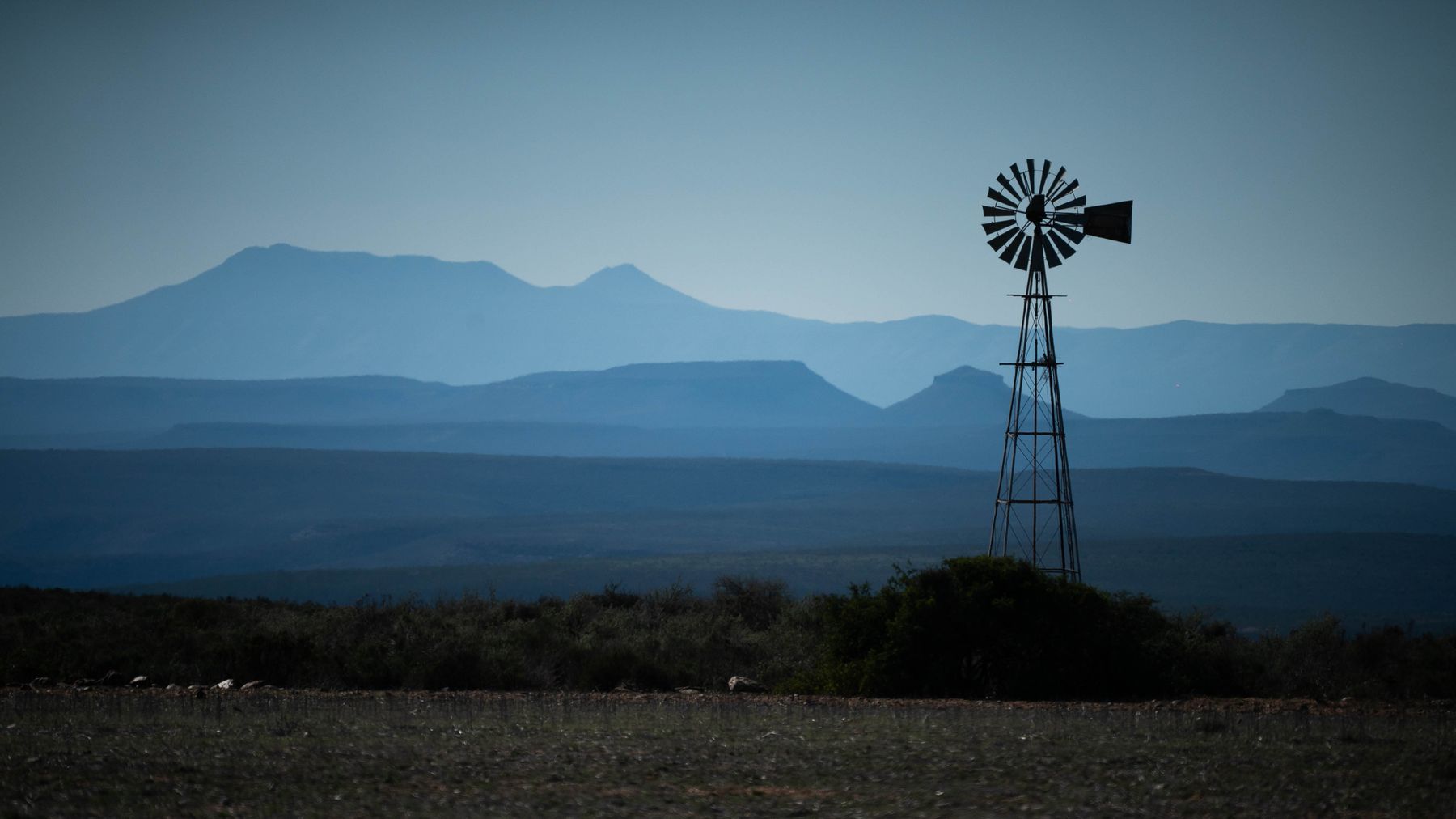 A windpump against blue mountains and sky